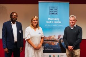 Speaker in front of Seminar Banner